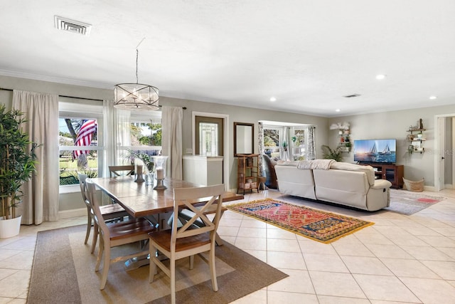 dining room featuring ornamental molding, an inviting chandelier, and light tile patterned floors