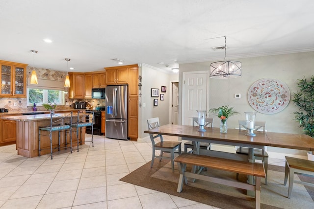 tiled dining room with ornamental molding and an inviting chandelier