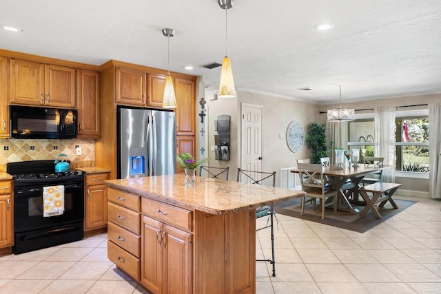 kitchen featuring light stone counters, a kitchen island, black appliances, a breakfast bar area, and decorative backsplash