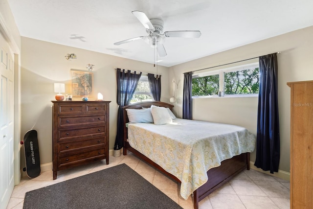 bedroom featuring light tile patterned flooring, ceiling fan, and a closet