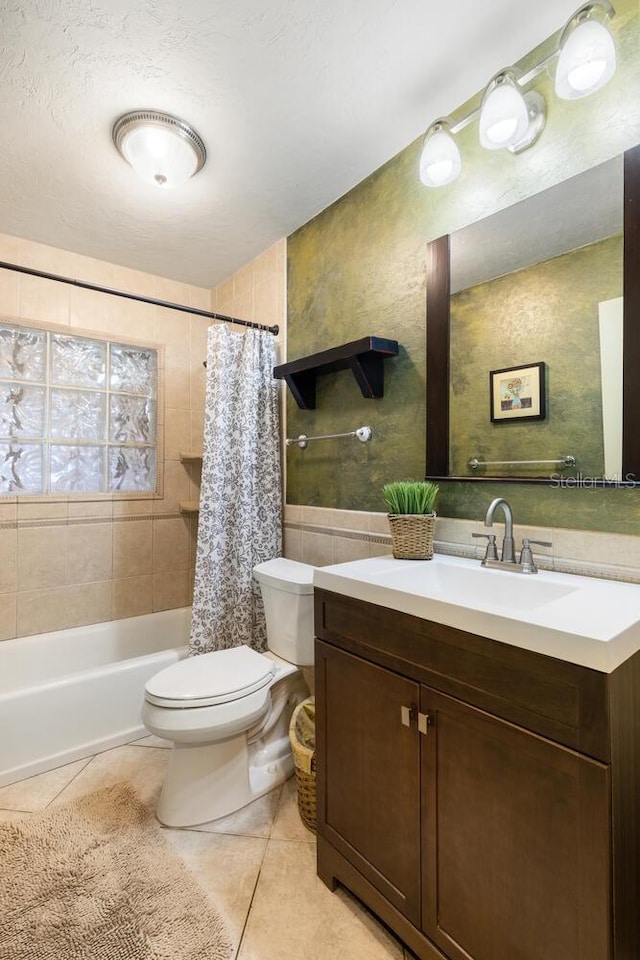 full bathroom with vanity, shower / bath combo, a textured ceiling, tile patterned floors, and toilet