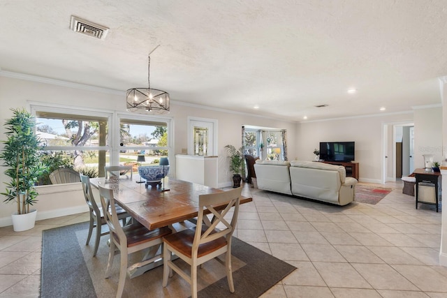 tiled dining room with ornamental molding, a textured ceiling, and a notable chandelier