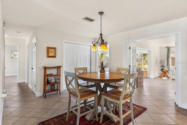 dining area with light tile patterned flooring and a notable chandelier