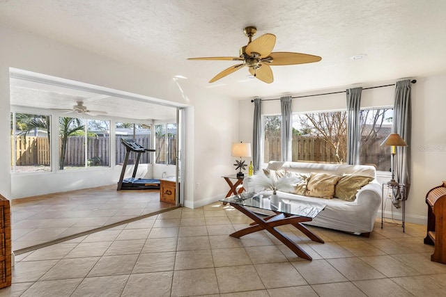 living room with light tile patterned flooring, ceiling fan, and a textured ceiling