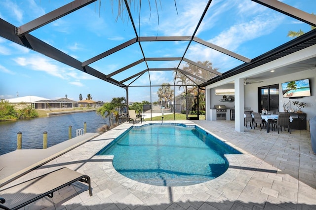 view of swimming pool with a water view, a patio, glass enclosure, and ceiling fan