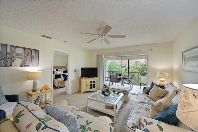 carpeted living room featuring a textured ceiling and ceiling fan