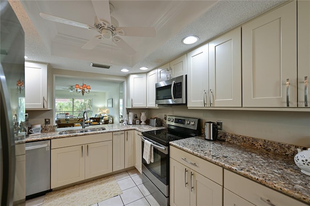 kitchen featuring light tile patterned floors, stainless steel appliances, a raised ceiling, visible vents, and a sink