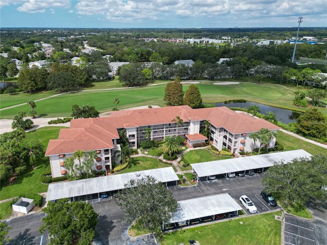 drone / aerial view with a water view and golf course view