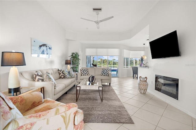 living room featuring ceiling fan, ornamental molding, and light tile patterned flooring