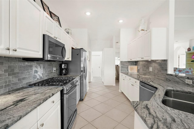 kitchen with tasteful backsplash, light stone counters, white cabinets, and stainless steel appliances