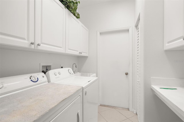 washroom featuring light tile patterned flooring, cabinets, and washing machine and clothes dryer