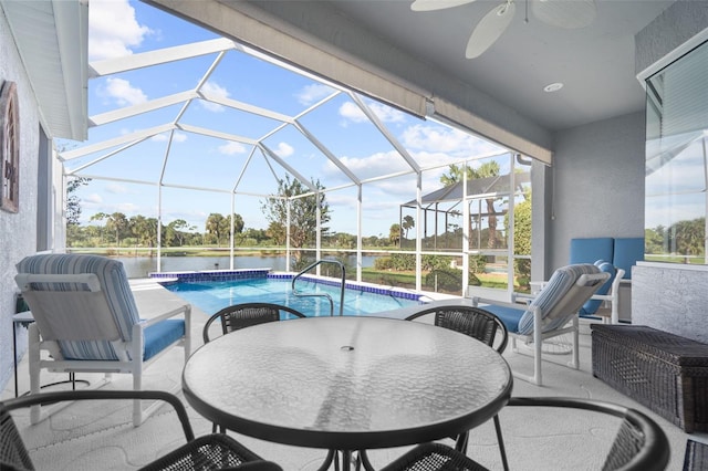 view of patio featuring a water view, ceiling fan, and a lanai