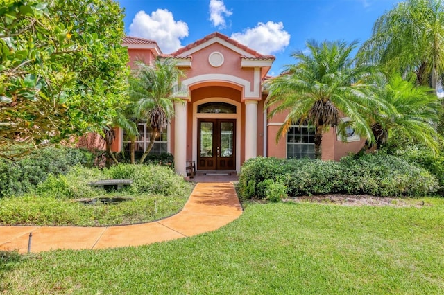 doorway to property featuring a lawn and french doors