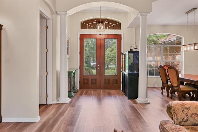 entrance foyer featuring hardwood / wood-style floors, an inviting chandelier, and french doors