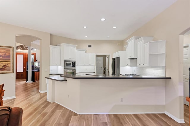 kitchen with kitchen peninsula, white cabinets, light wood-type flooring, and appliances with stainless steel finishes