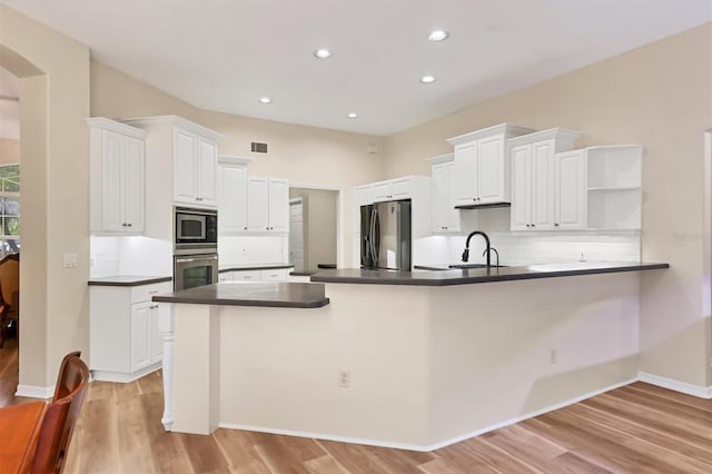 kitchen featuring kitchen peninsula, light hardwood / wood-style flooring, white cabinets, and stainless steel appliances