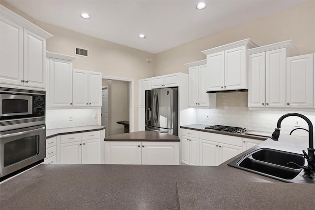 kitchen featuring white cabinets, decorative backsplash, sink, and appliances with stainless steel finishes