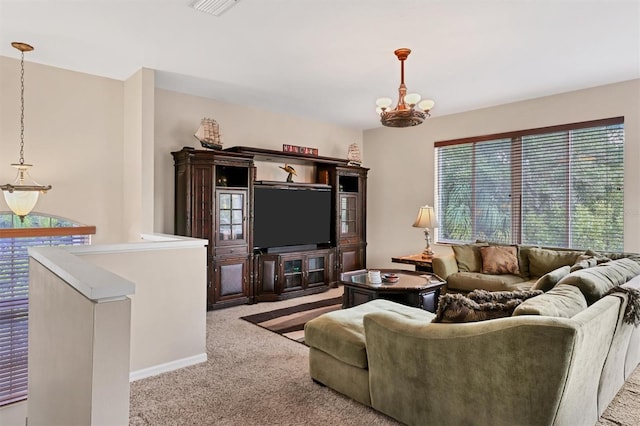 carpeted living room featuring a notable chandelier