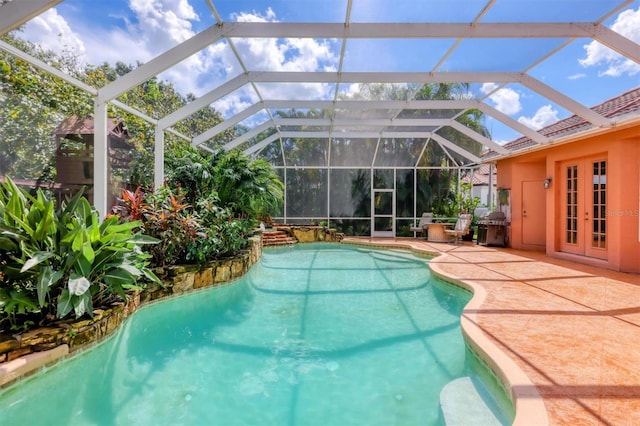 view of pool featuring french doors, a patio area, and a lanai