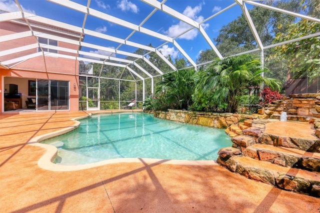 view of pool featuring glass enclosure and a patio area