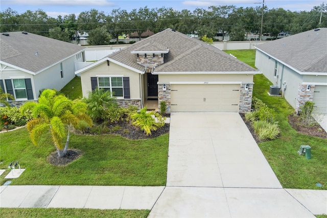 view of front facade with a front yard, cooling unit, and a garage