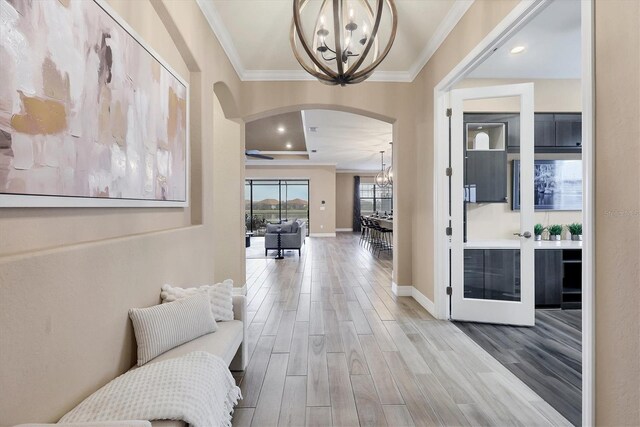 hallway featuring a chandelier, hardwood / wood-style flooring, and ornamental molding