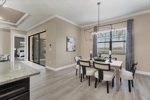 dining area featuring a chandelier, light hardwood / wood-style floors, and crown molding