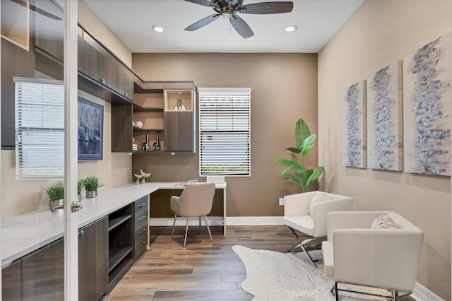 office space with ceiling fan, light wood-type flooring, and built in desk