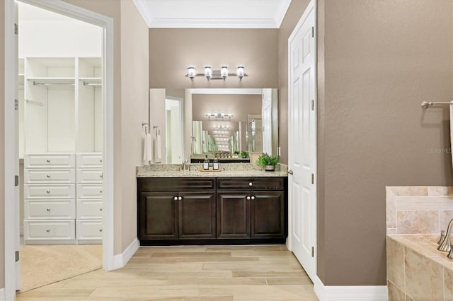 bathroom featuring hardwood / wood-style floors, vanity, a bathtub, and crown molding