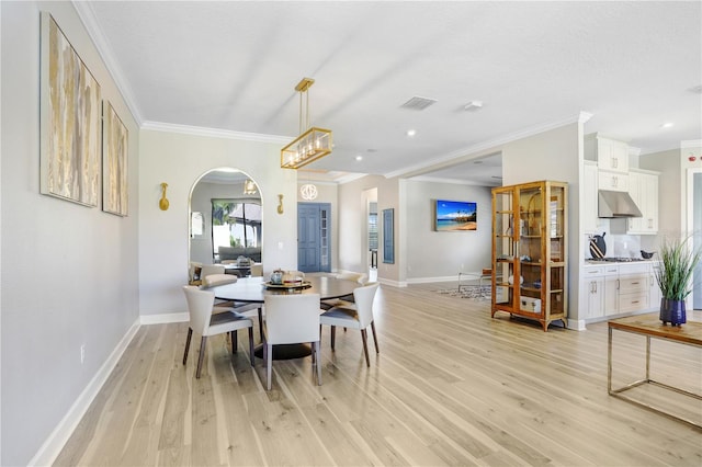 dining area featuring light hardwood / wood-style flooring and crown molding