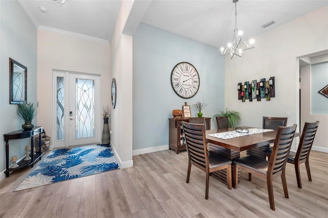 dining space with a notable chandelier, light hardwood / wood-style flooring, and ornamental molding