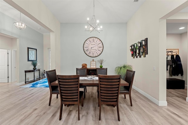 dining space with a notable chandelier and light hardwood / wood-style floors