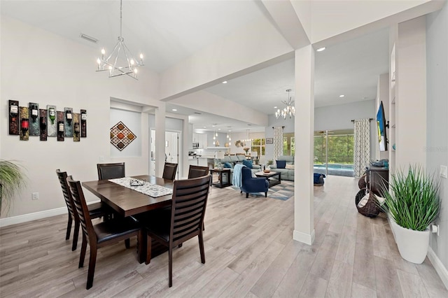 dining space featuring light wood-type flooring and an inviting chandelier