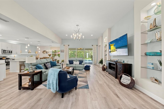 living room with light wood-type flooring, a chandelier, and built in shelves