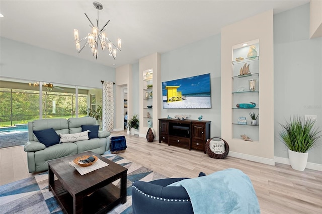 living room featuring light hardwood / wood-style flooring, built in shelves, and a notable chandelier