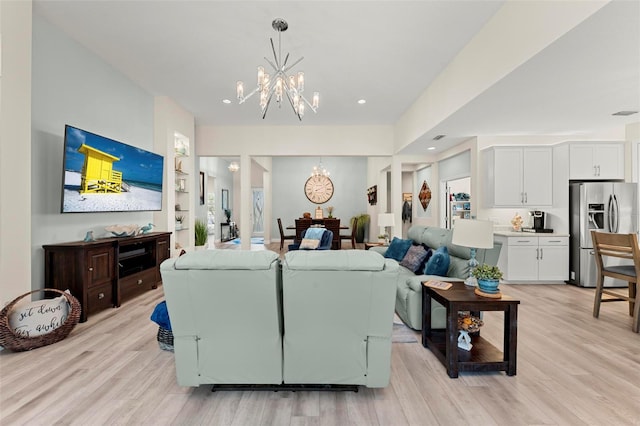 living room with an inviting chandelier and light hardwood / wood-style flooring