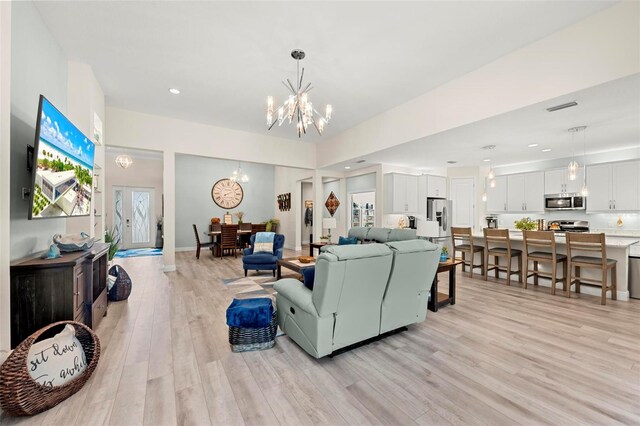 living room featuring light wood-type flooring and a notable chandelier