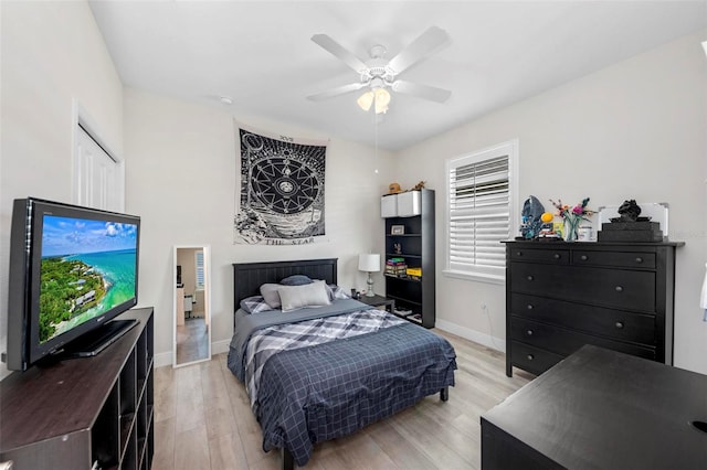 bedroom with light hardwood / wood-style floors, ceiling fan, and a closet