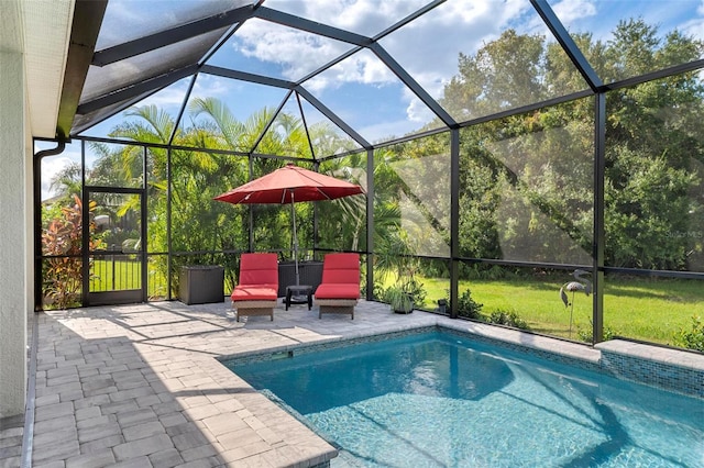 view of pool featuring a yard, glass enclosure, and a patio