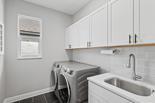 washroom featuring washer and dryer, dark tile patterned floors, cabinets, and sink