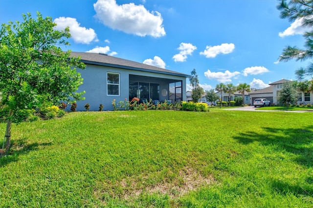 view of yard with a garage and a sunroom