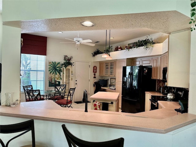 kitchen featuring ceiling fan, hanging light fixtures, kitchen peninsula, a textured ceiling, and black appliances