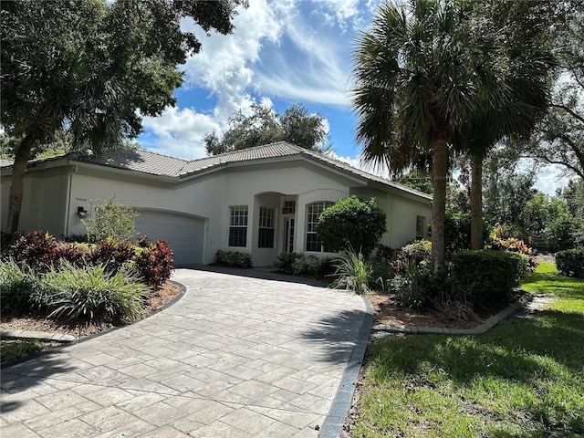 5658 Downham Mdws, Sarasota, FL 34235 - view of front of house featuring driveway, stucco siding, an attached garage, and a tile roof