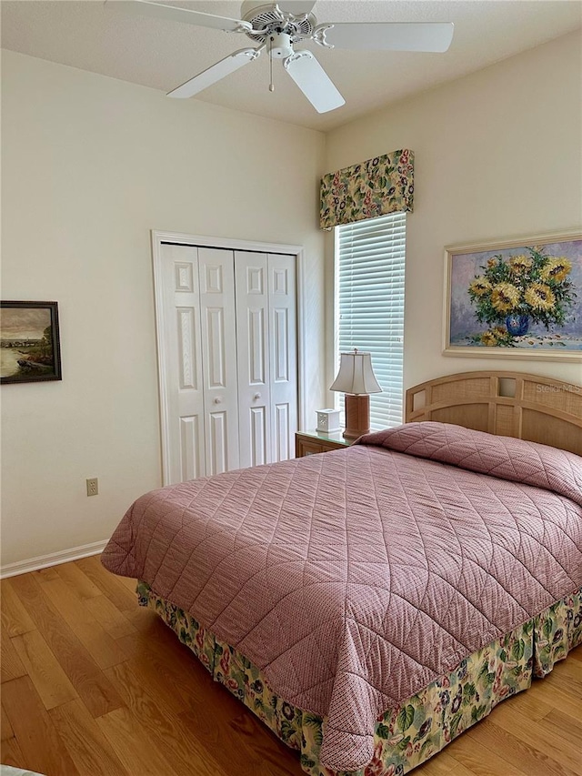 bedroom featuring hardwood / wood-style flooring, ceiling fan, and a closet