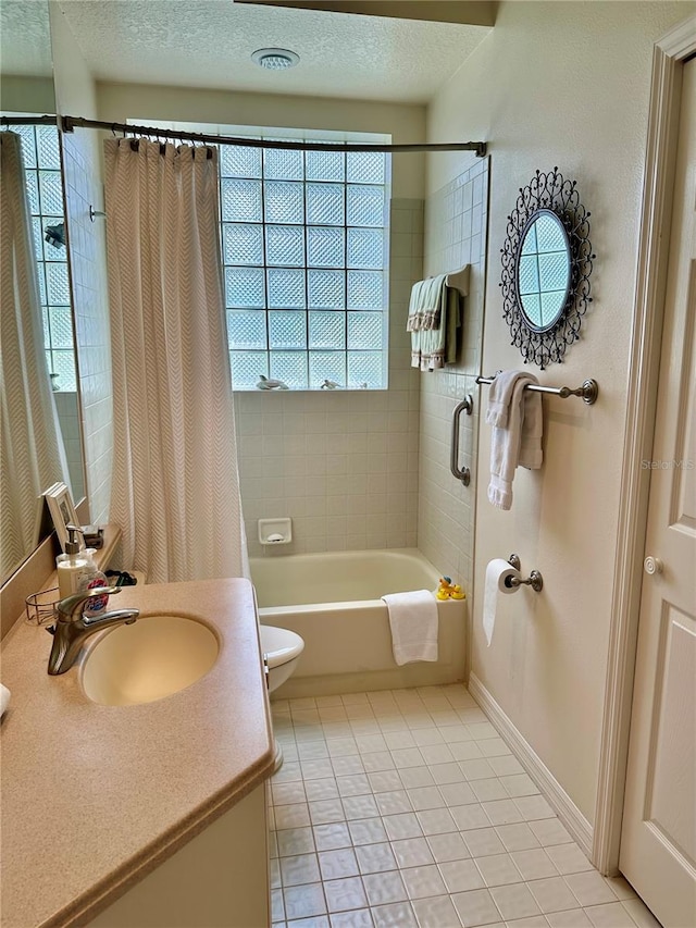 full bathroom with vanity, a textured ceiling, shower / bath combo with shower curtain, tile patterned floors, and toilet