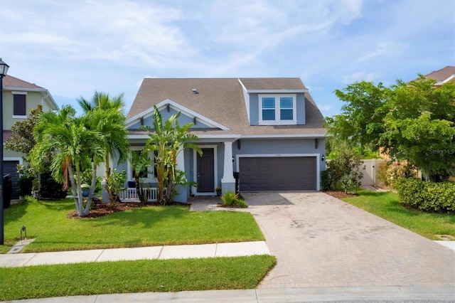 view of front of home featuring a garage, a front lawn, and covered porch