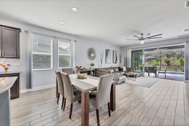 dining room with a wealth of natural light, ceiling fan, and light wood-type flooring