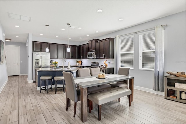 dining space with light hardwood / wood-style flooring and sink