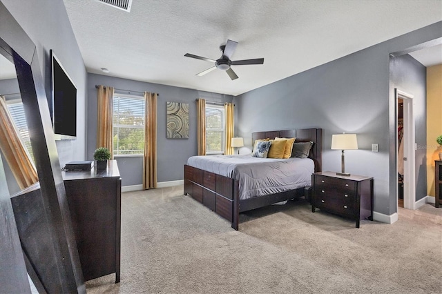 carpeted bedroom featuring a textured ceiling and ceiling fan