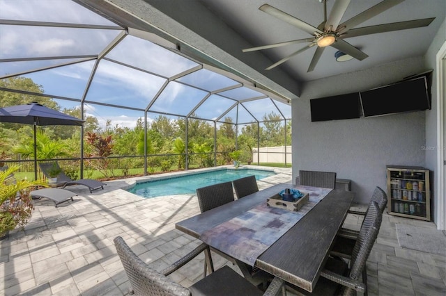 view of pool with glass enclosure, ceiling fan, and a patio area